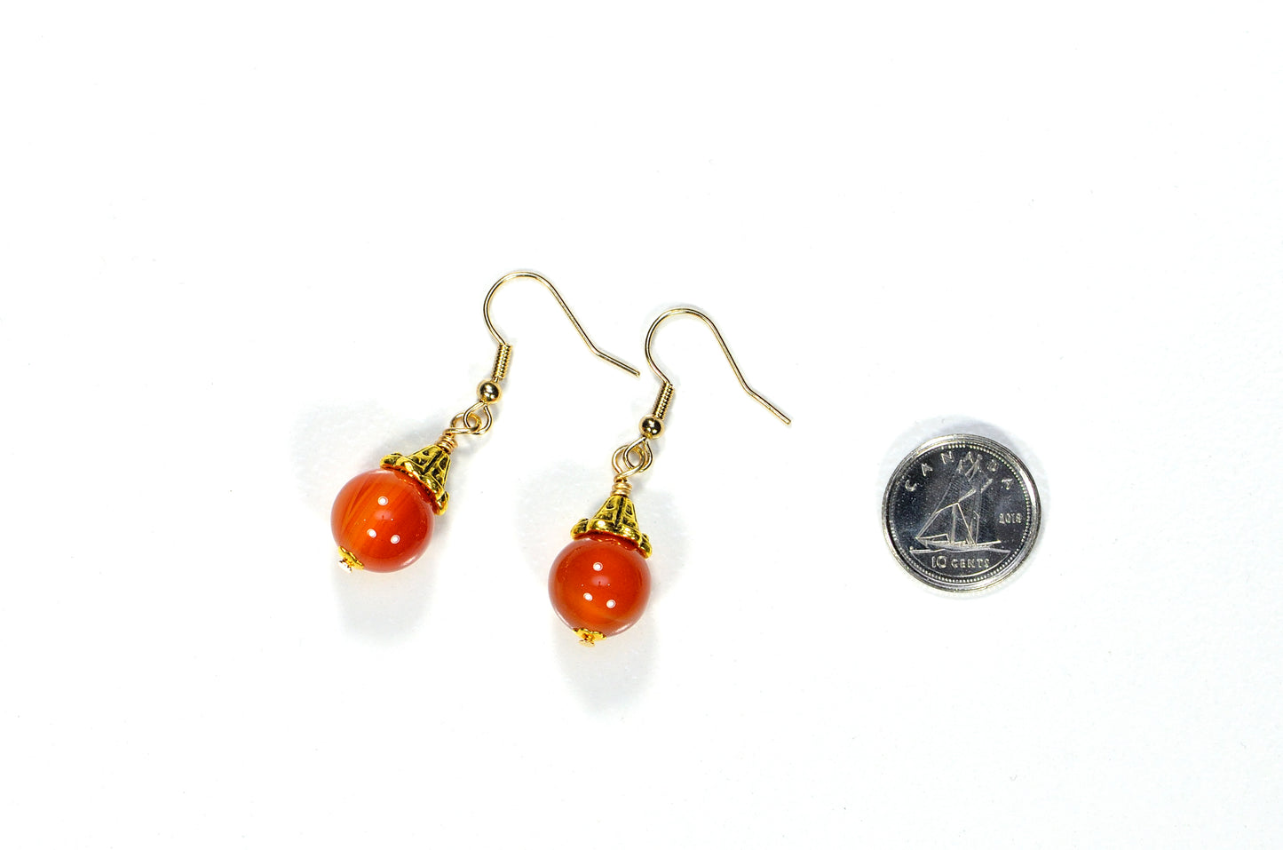 12mm Natural Carnelian Crystal Drop Earrings beside a dime.