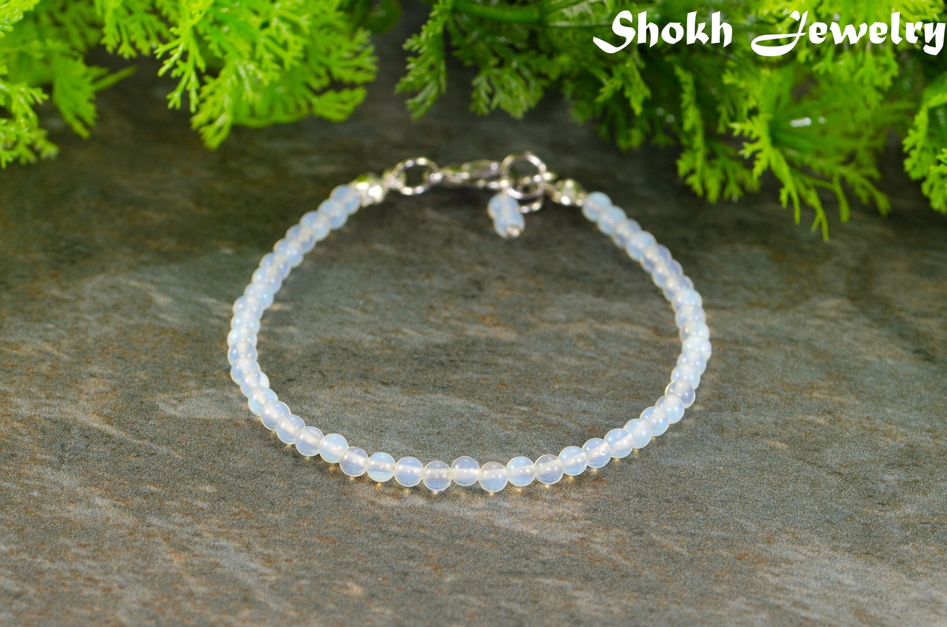 3mm Clear White Opalite Bracelet on a stone surface.