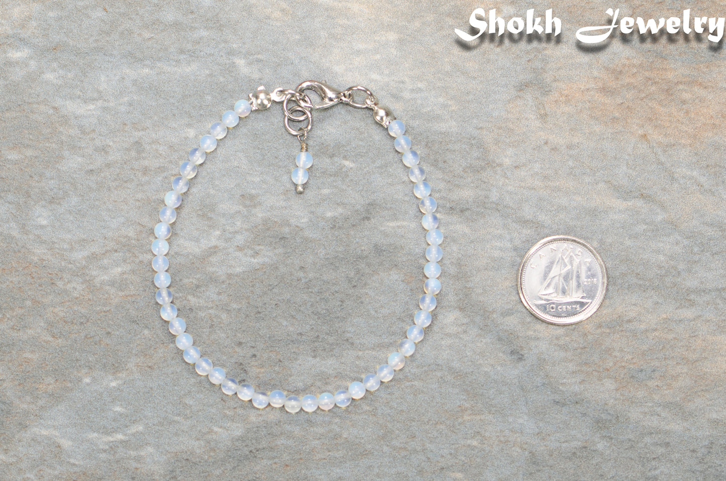 3mm Clear White Opalite Bracelet beside a dime.