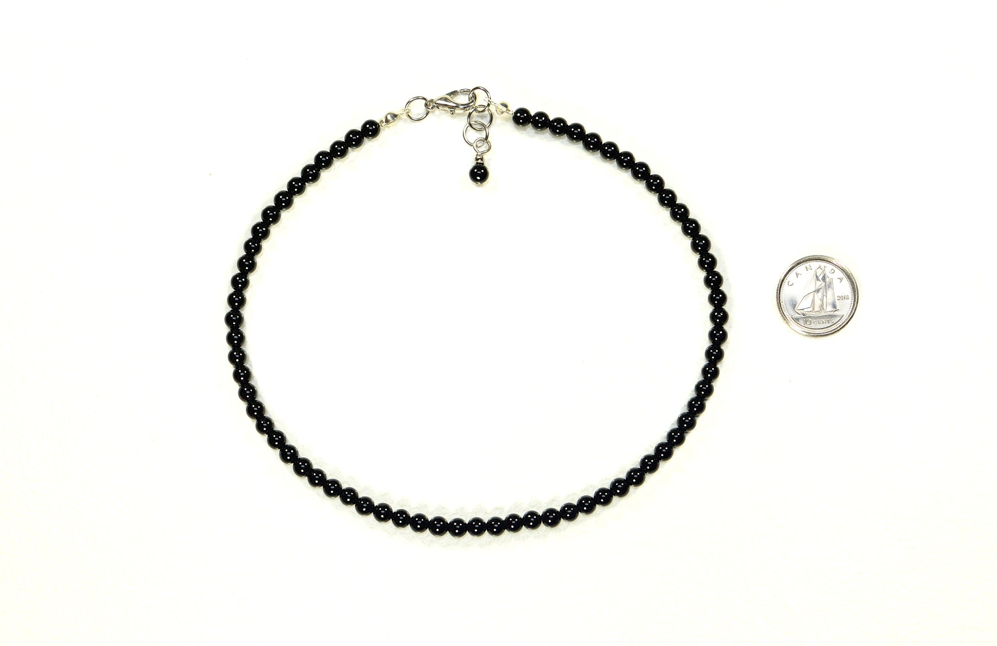 4mm Black Obsidian Crystal Choker Necklace beside a dime.
