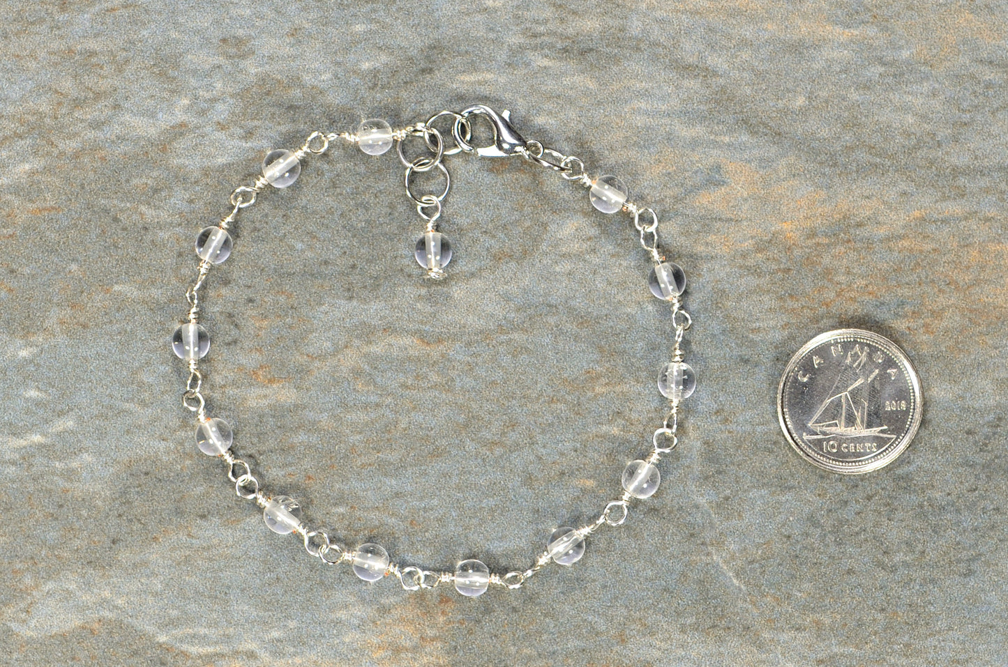 4mm Clear Quartz Link Bracelet beside a dime.