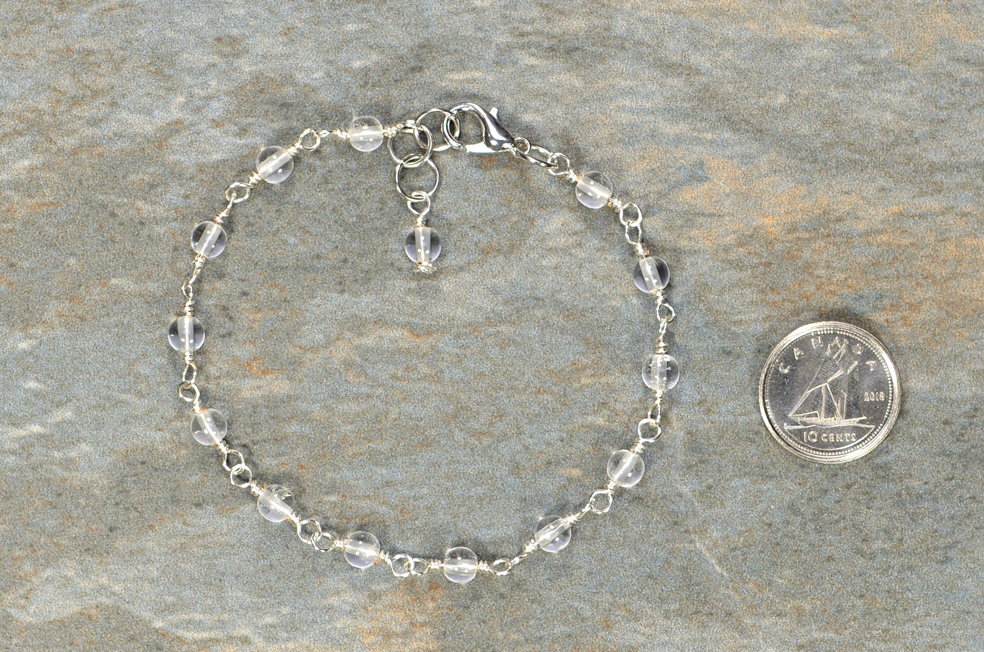4mm Clear Quartz Link Bracelet beside a dime.