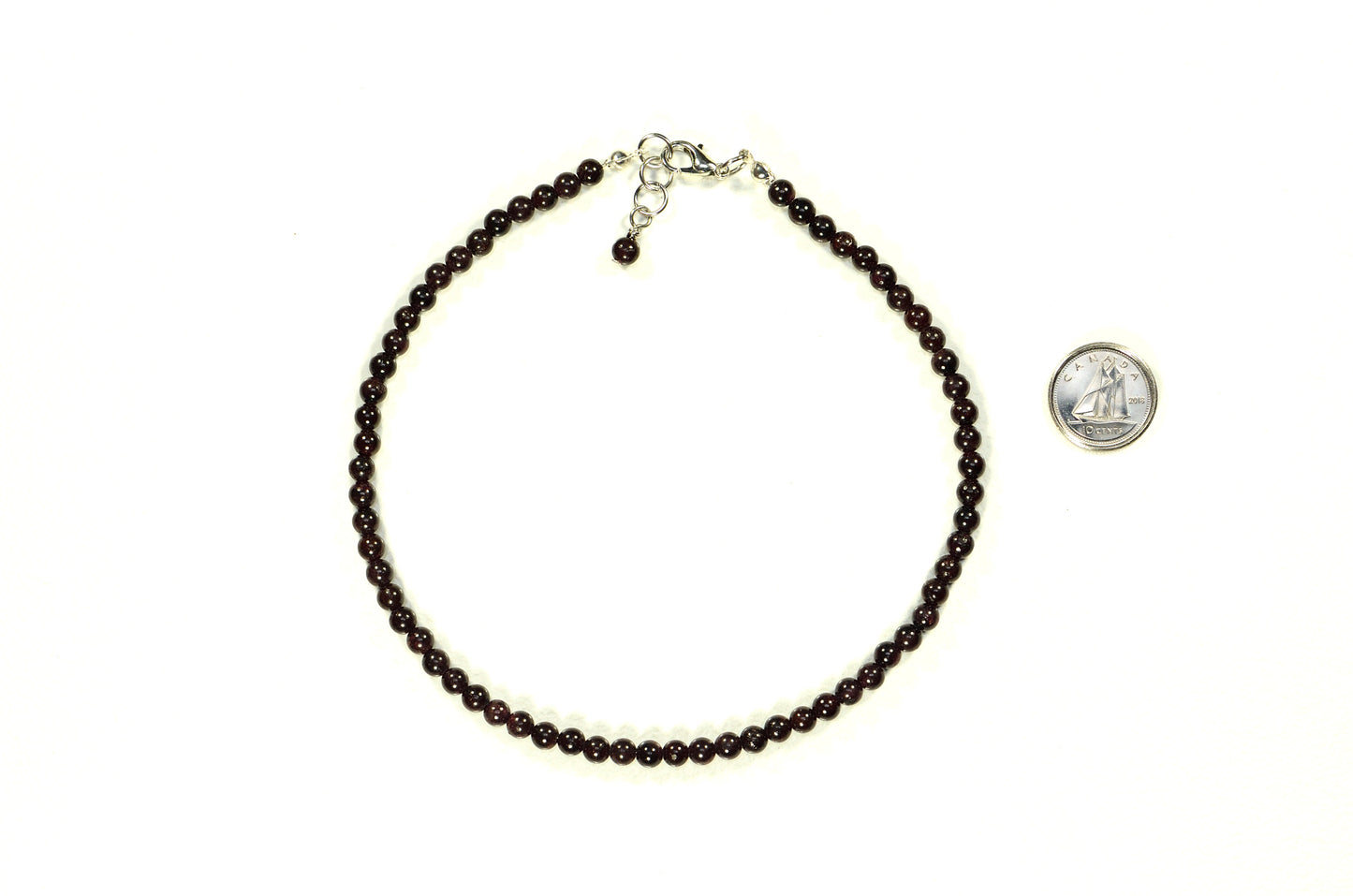 4mm Garnet Crystal Choker Necklace beside a dime.