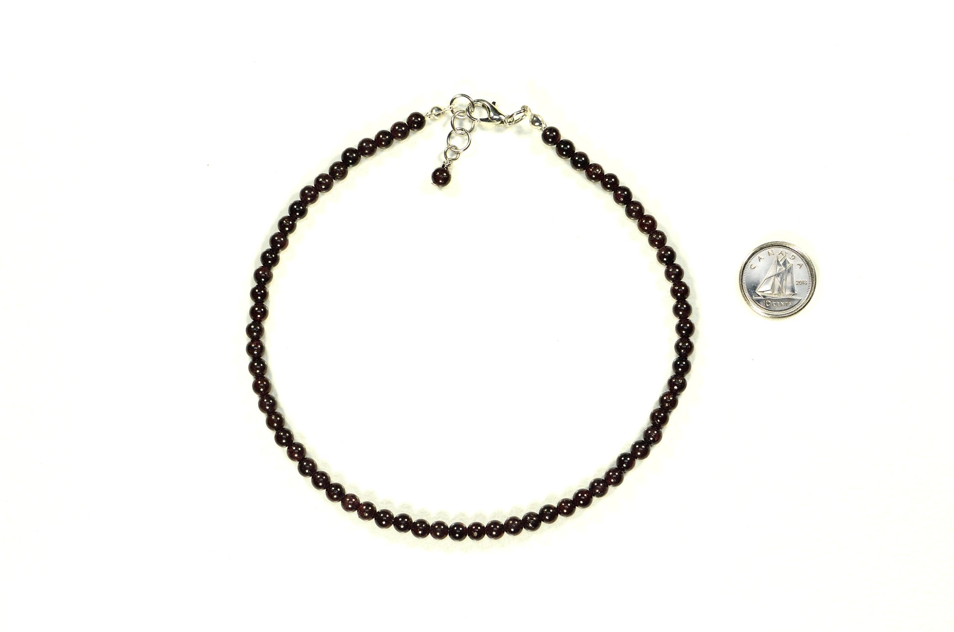 4mm Garnet Crystal Choker Necklace beside a dime.