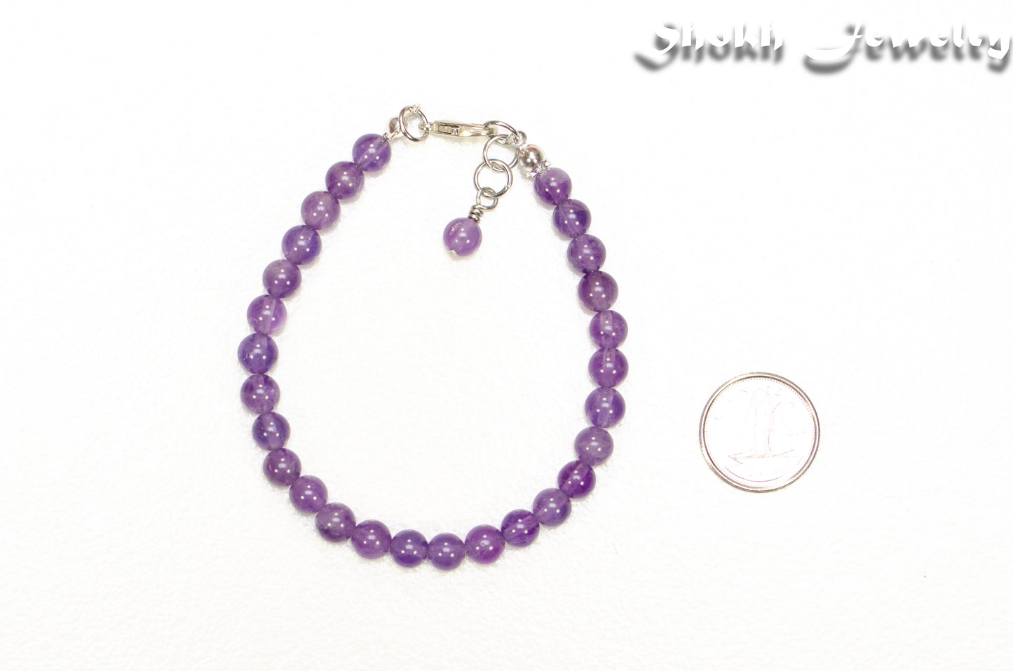 6mm Amethyst Crystal Bracelet beside a dime.