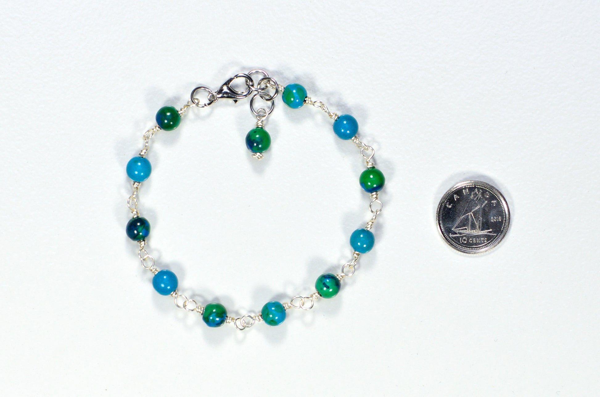 6mm Blue Jade Link Bracelet beside a dime.