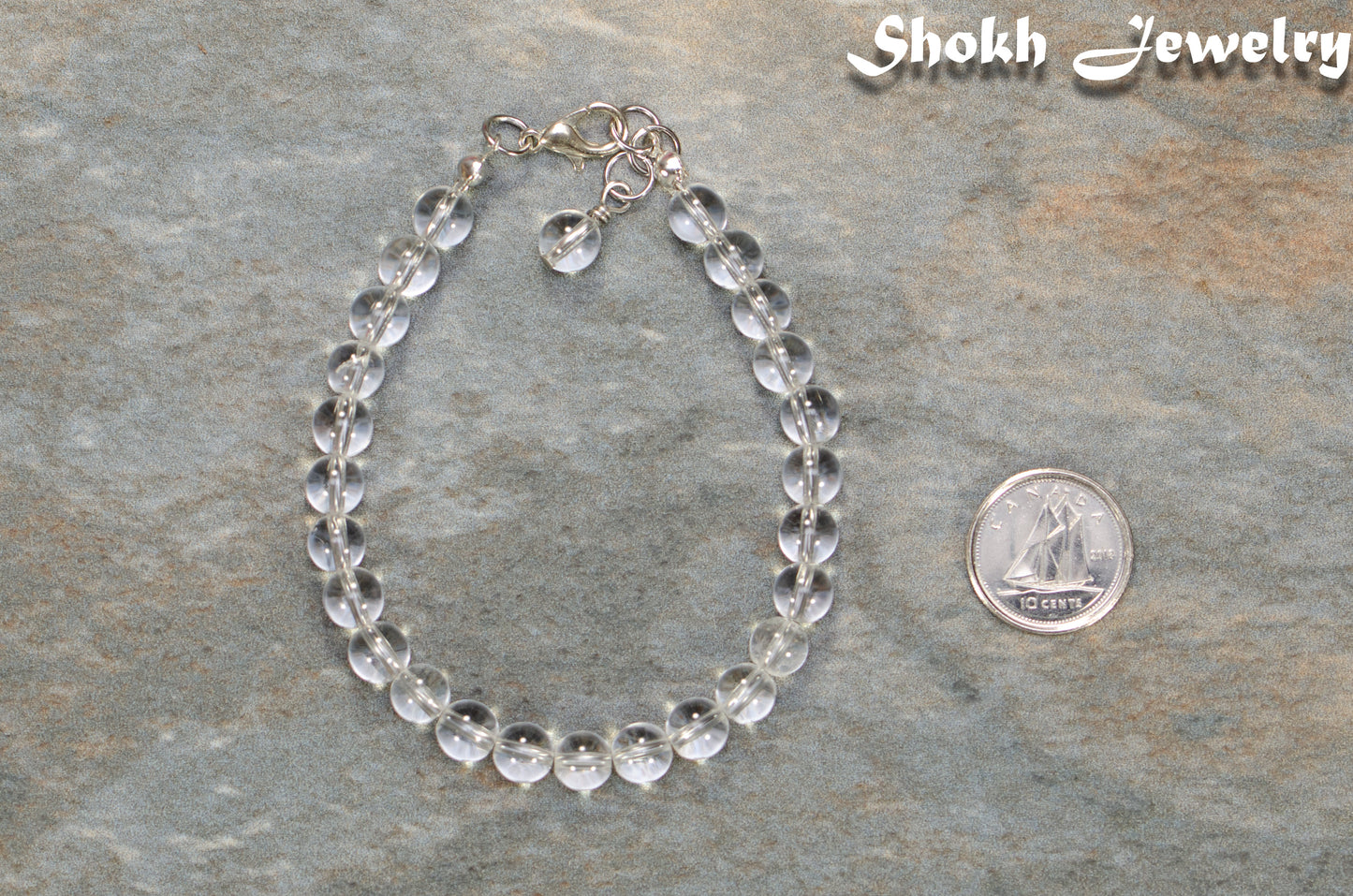 6mm Clear Quartz Beaded Bracelet beside a dime.