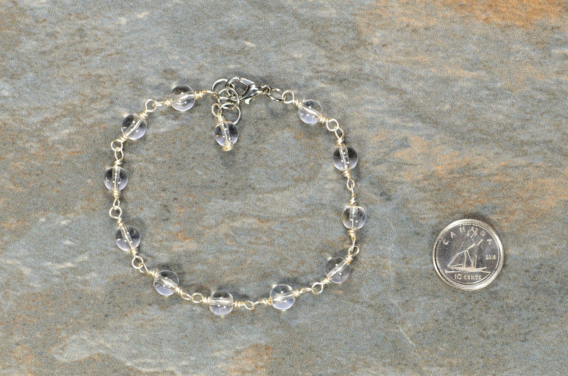  6mm Clear Quartz Link Bracelet beside a dime.