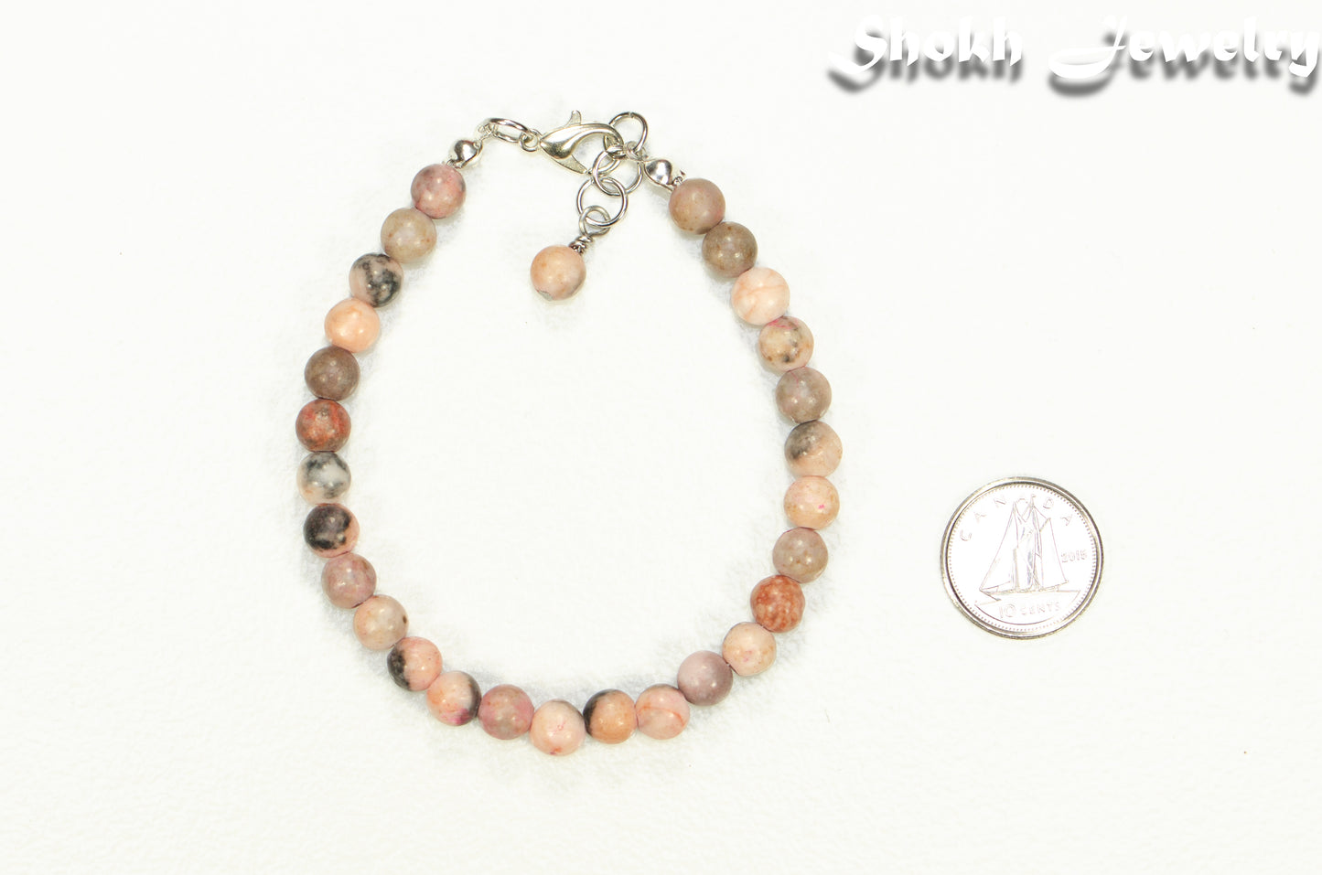 6mm Pink Zebra Jasper Beaded Bracelet beside a dime.