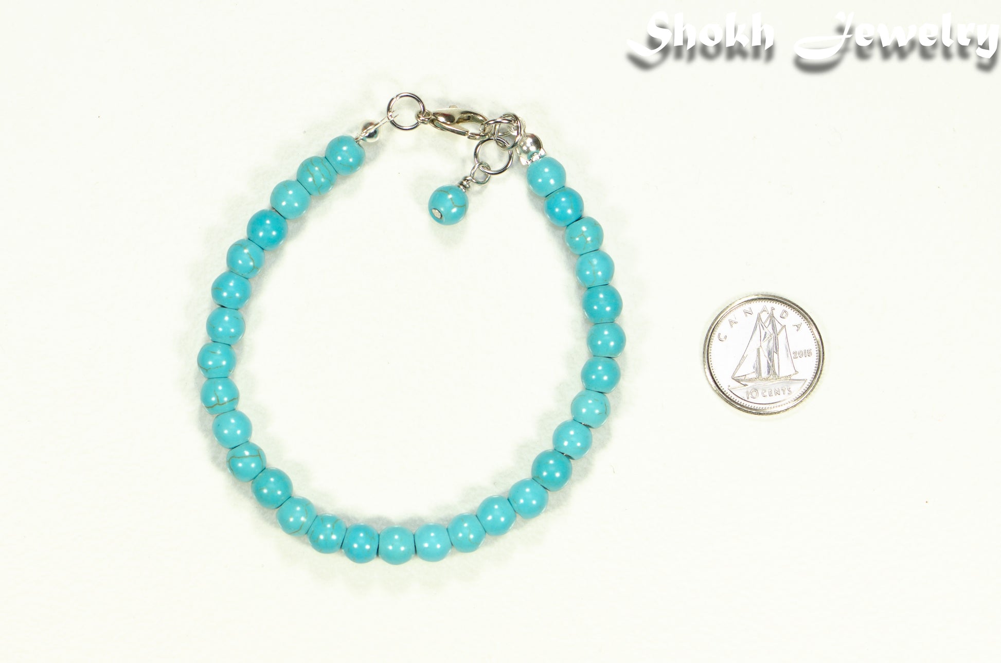 6mm Turquoise Howlite Beaded Bracelet beside a dime.