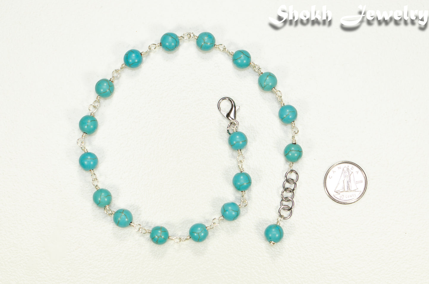 8mm Turquoise Howlite Link Choker Necklace beside a dime.