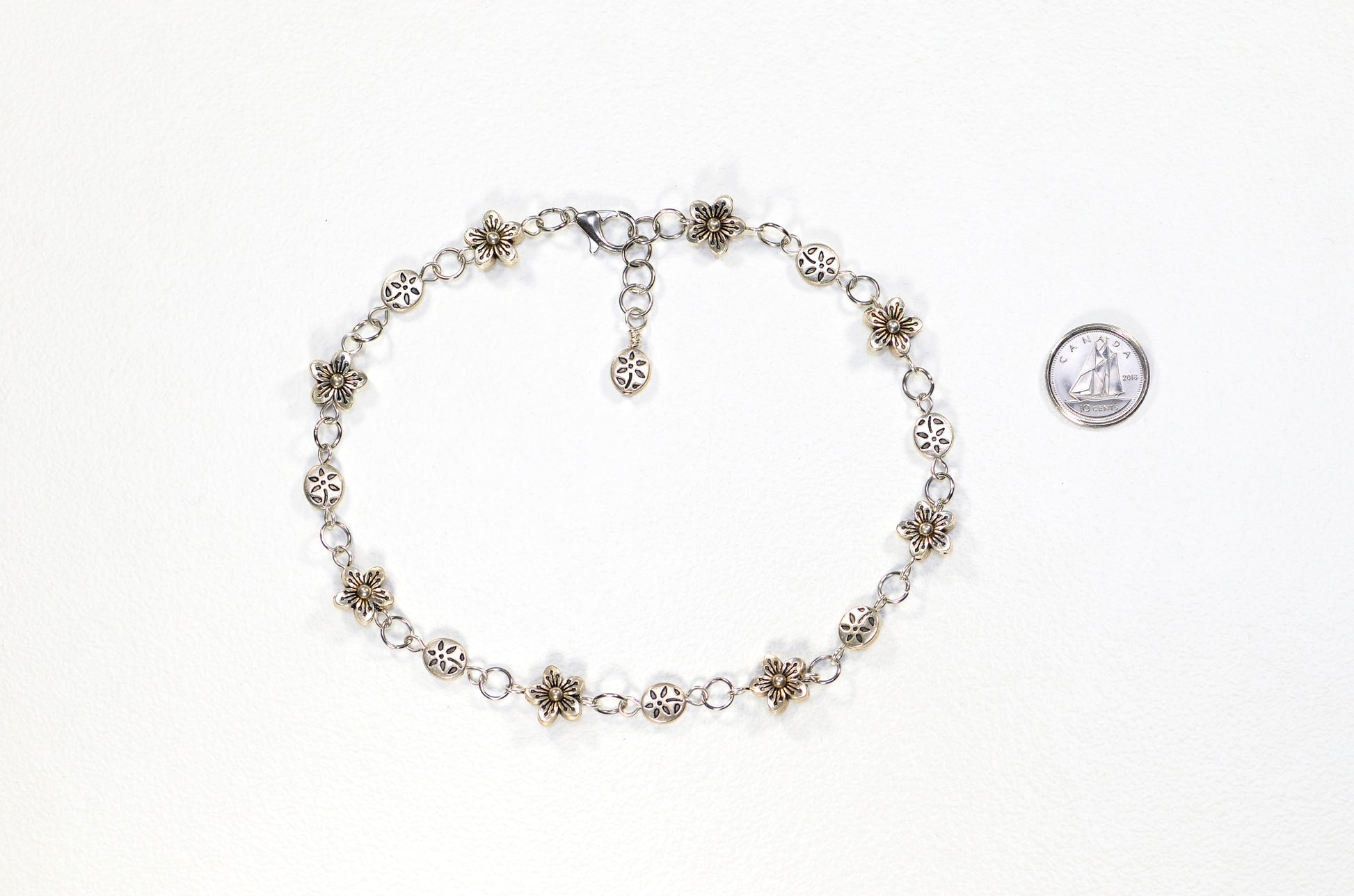 Chunky Tibetan Silver Flower Choker Necklace beside a dime.