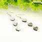 Close up of Long Grey Seashell Hearts Earrings.