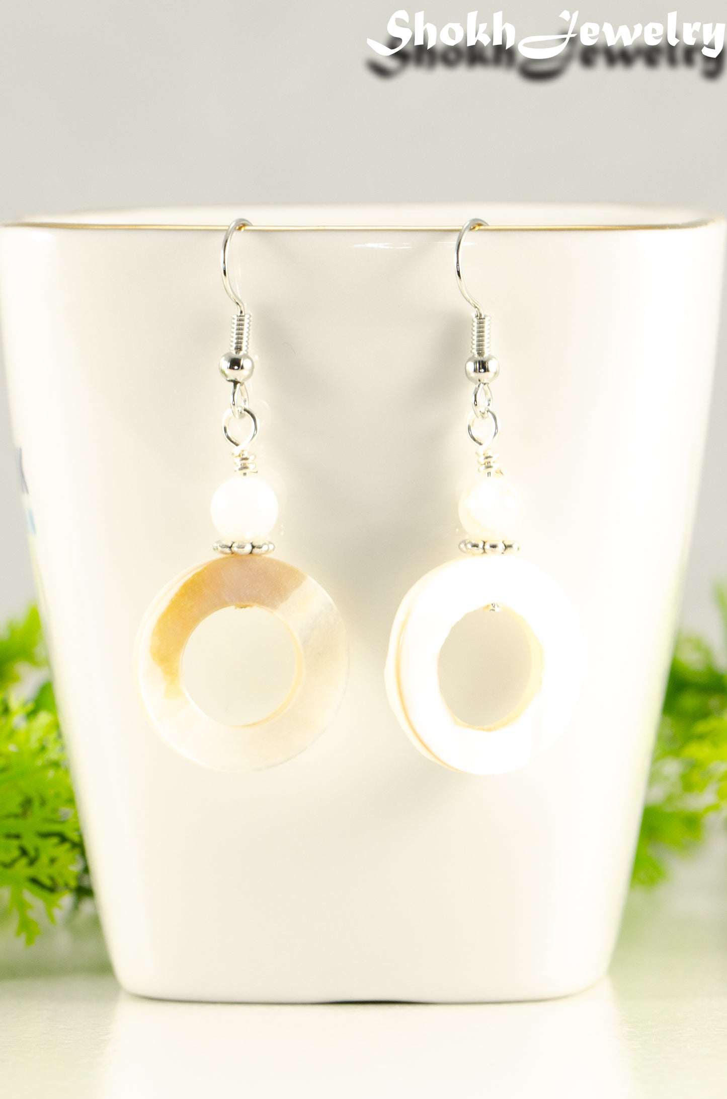 Close up of White Doughnut Seashell Earrings.