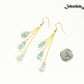 Long Gold Plated Chain and Aquamarine Crystal Chip Earrings beside a dime.