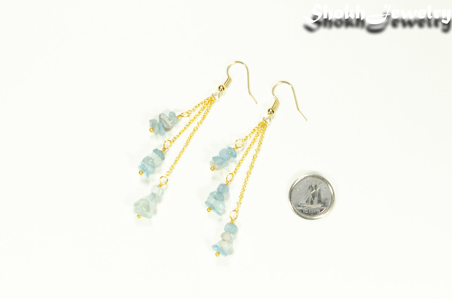 Long Gold Plated Chain and Aquamarine Crystal Chip Earrings beside a dime.