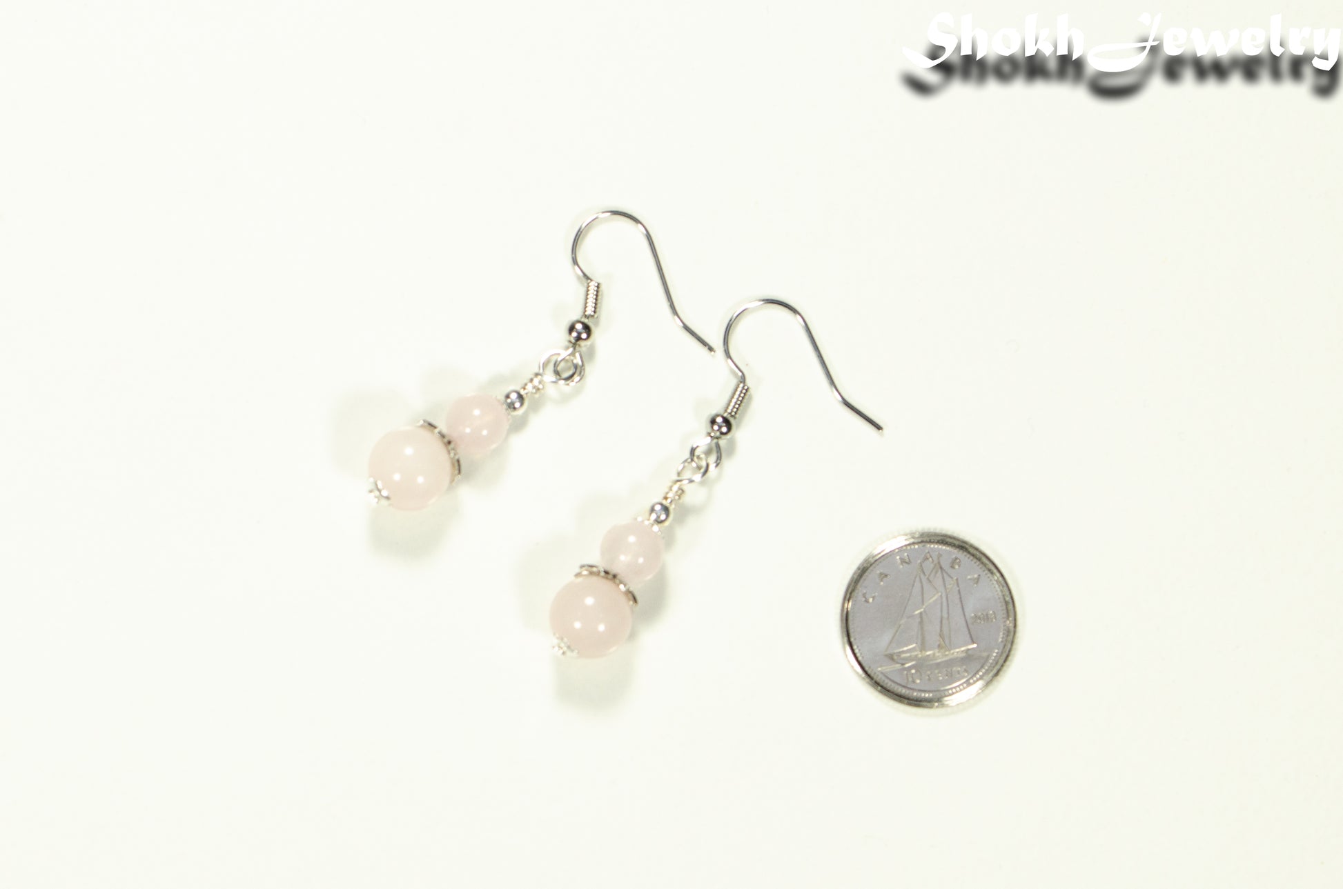 Small Rose Quartz Earrings beside a dime.