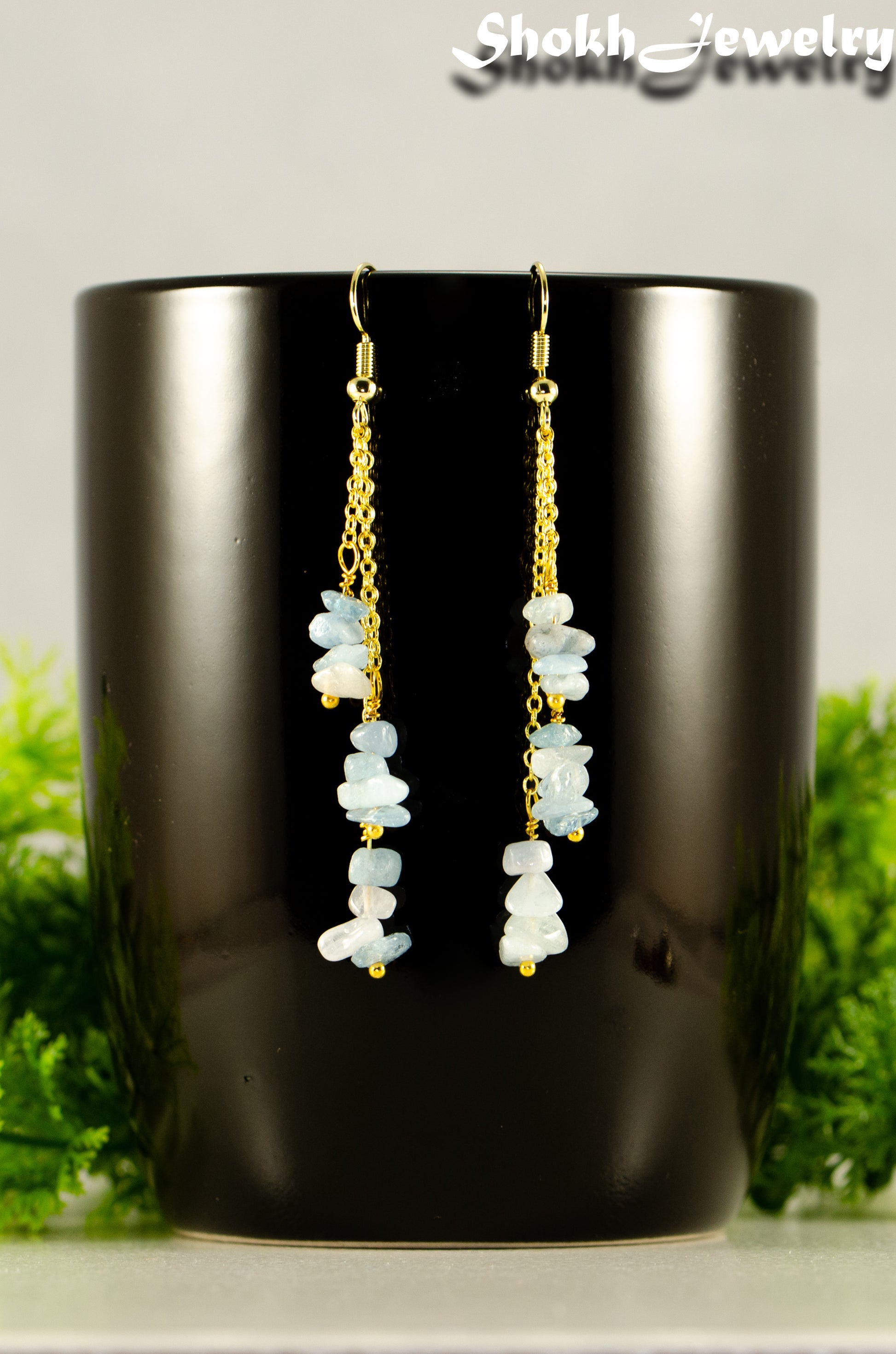 Close up of Long Gold Plated Chain and Aquamarine Crystal Chip Earrings.
