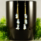 Long Gold Plated Chain and Aquamarine Crystal Chip Earrings on a coffee mug.