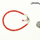 4mm Natural Red Coral Bracelet with Clasp beside a dime.
