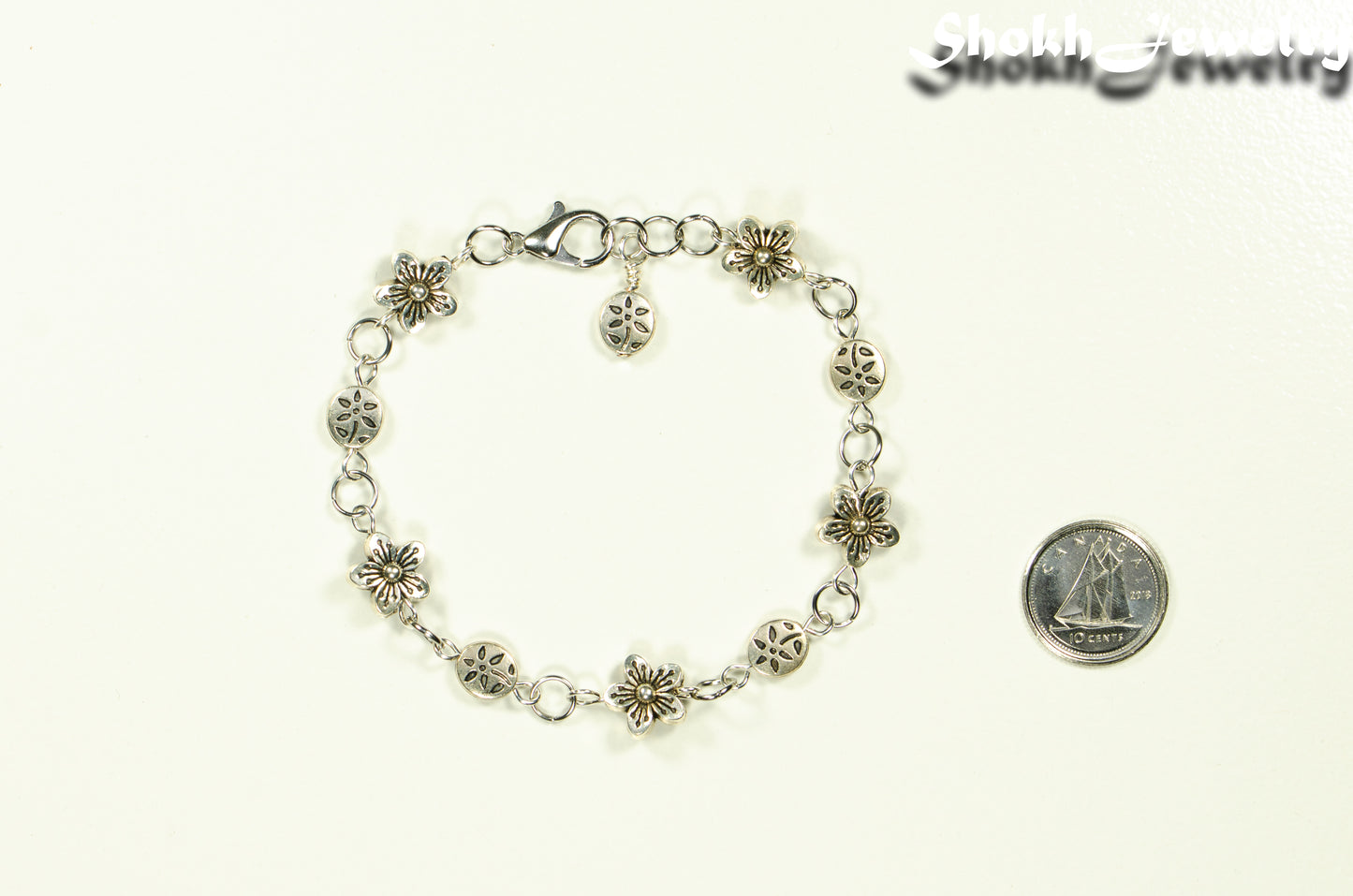 Tibetan Silver Flower Link Bracelet beside a dime.