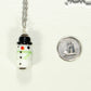 Glass Bead Snowman Pendant beside a dime.