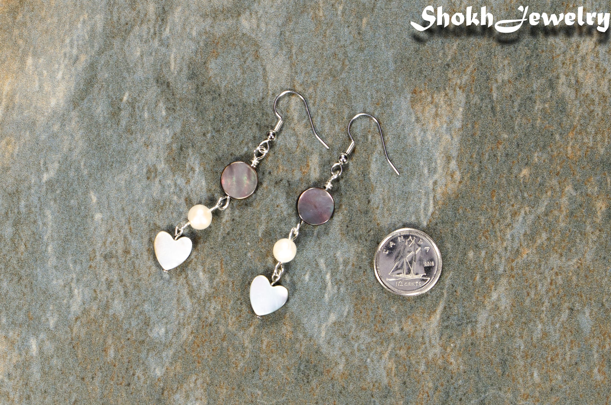 Grey Seashell and White Pearl Earrings beside a dime.
