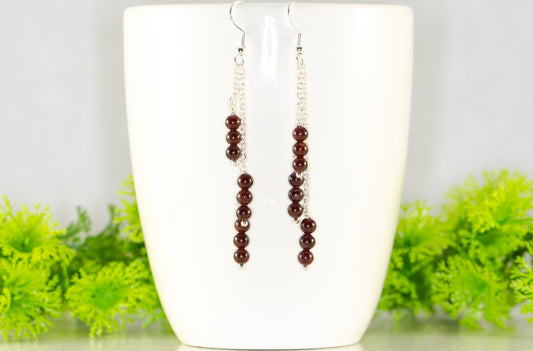 Silver Plated Chain and Garnet Crystal Earrings displayed on a coffee mug.