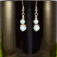 Small Opalite Crystal Earrings displayed on a coffee mug.