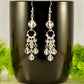 Statement Clear Quartz Chandelier Earrings displayed on a coffee mug.