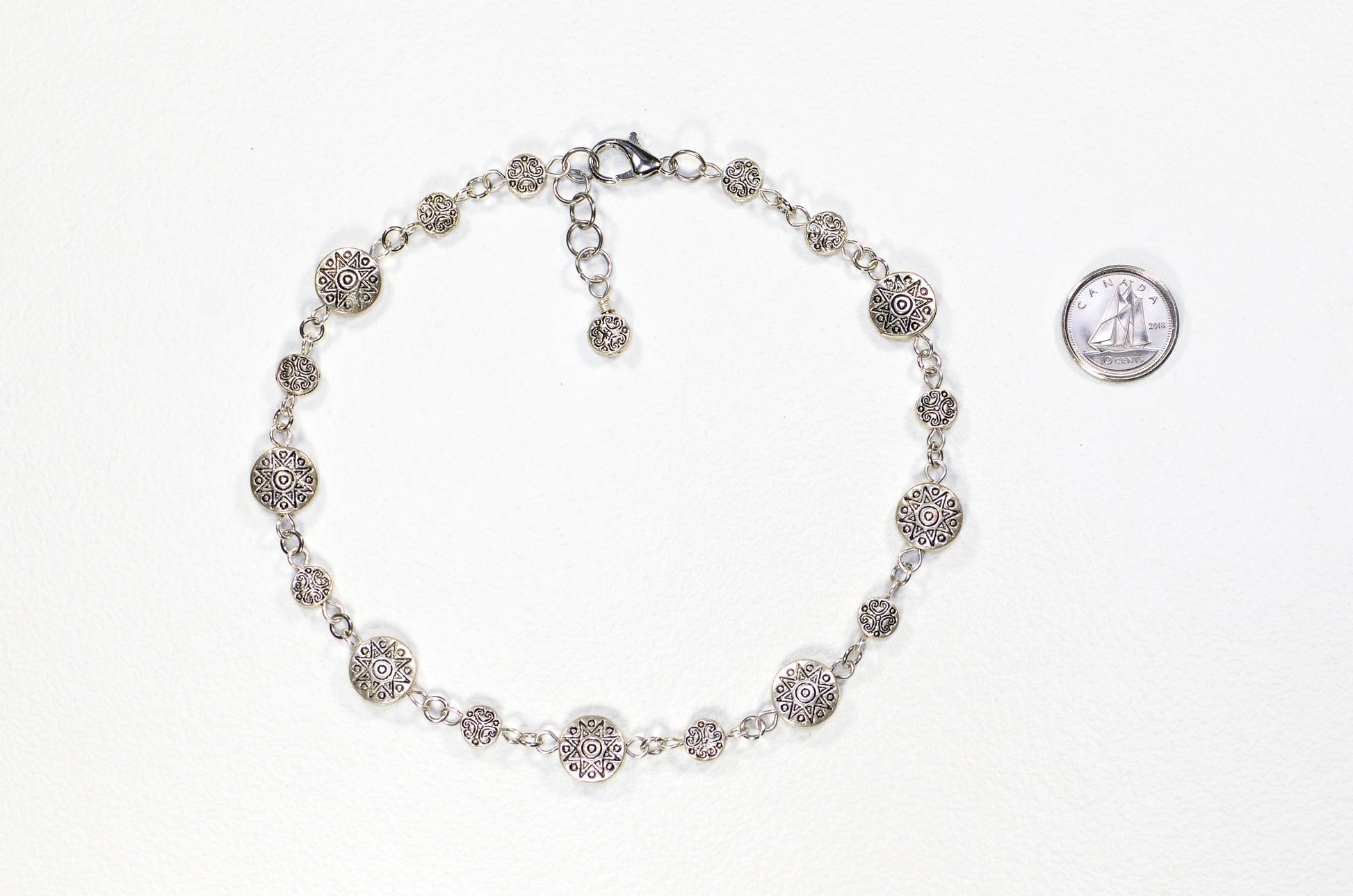 Tibetan Silver Star Sun and Moon Choker Necklace beside a dime.