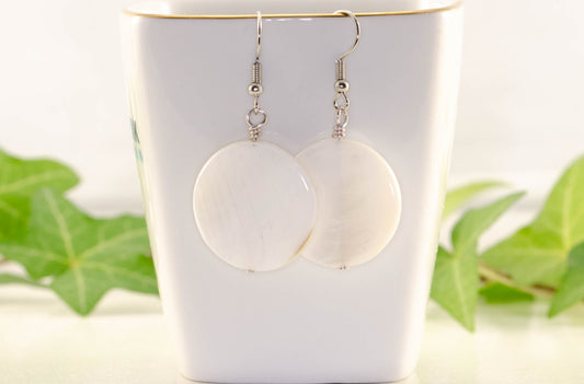 25mm White Seashell Earrings displayed on a tea cup.
