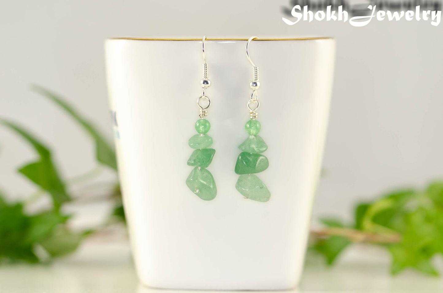 Natural Green Aventurine Crystal Chip Earrings on a tea cup
