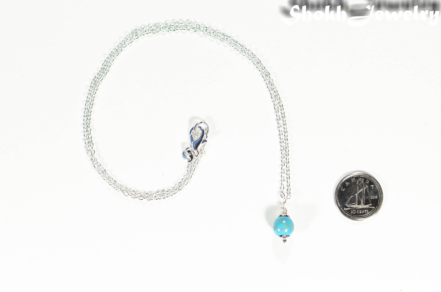 Dainty Turquoise Howlite Choker Necklace beside a dime