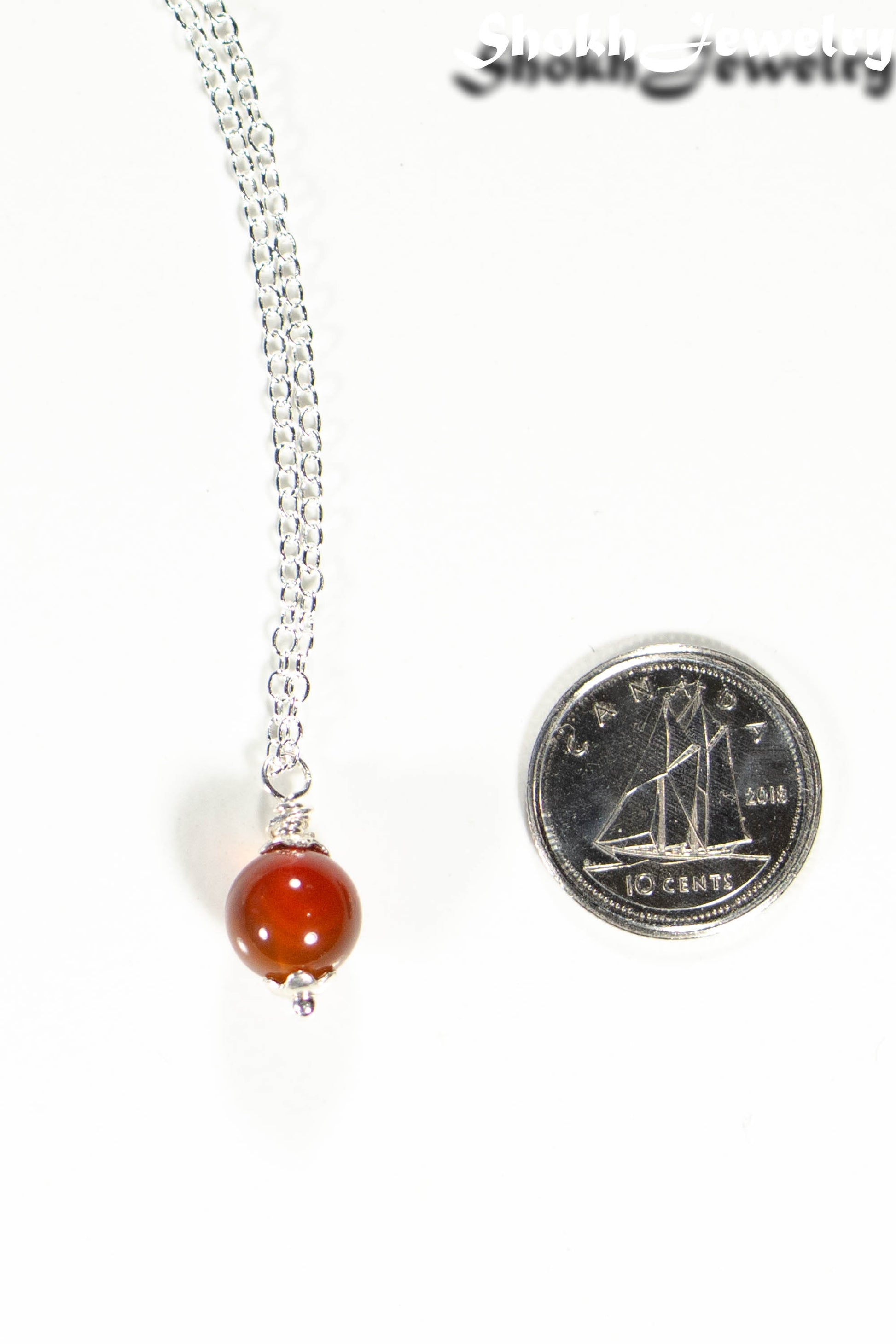 Dainty Carnelian pendant Choker Necklace beside a dime