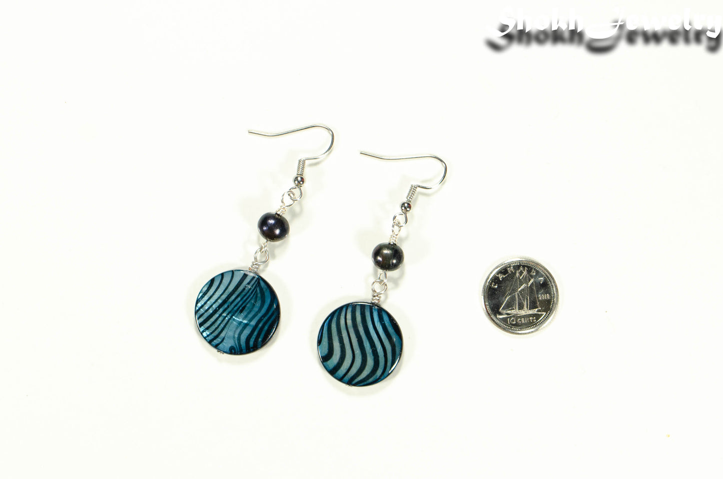 Long Blue Seashell and Pearl Earrings beside a dime.