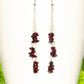 Long Silver Plated Chain and Garnet Crystal Chip Earrings on a mug
