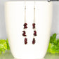 Long Silver Plated Chain and Garnet Crystal Chip Earrings on  a coffee mug.